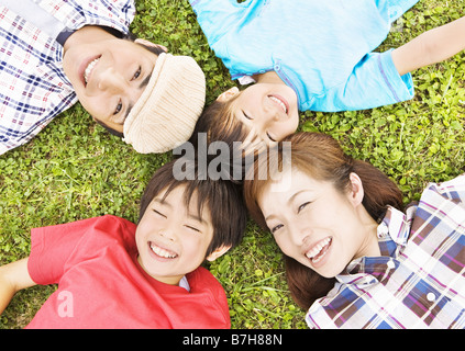 Family lying on the grass Stock Photo