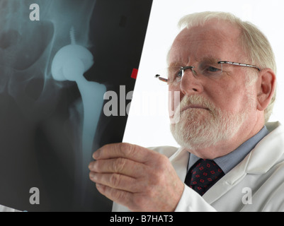 MALE DOCTOR WITH XRAY OF ARTIFICIAL HIP JOINT Stock Photo