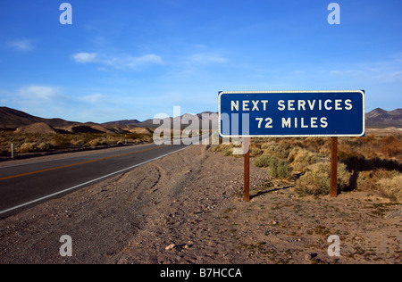 Next Service road sign. Desert road leading to Death Valley National Park, California USA Stock Photo