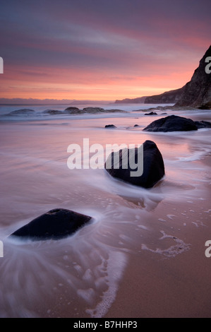 Scenic landscape image of Whiterocks beach at sunrise with movement in the waves, near Portrush County Antrim Northern Ireland Stock Photo