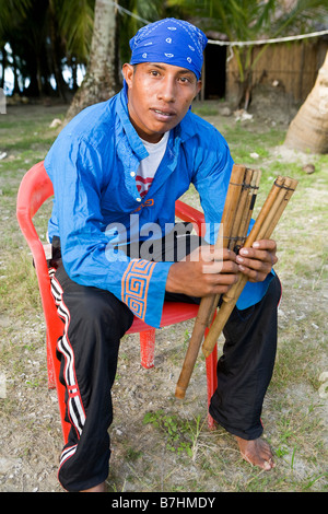 Kuna male holding traditional musical pipes before practicing  local dance on Isla Pelikano, San Blas Islands, Kuna Yala, Panama Stock Photo