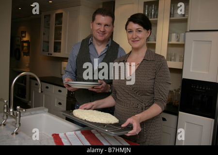 Couple preparing a fast-food pizza in their kitchen Stock Photo