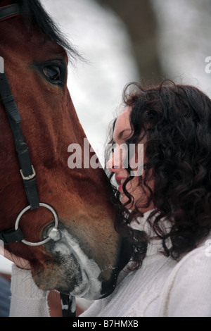 Lovely woman standing by horse outdoors Stock Photo