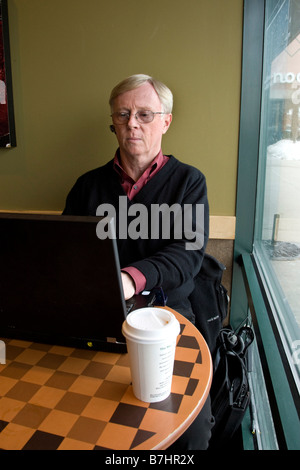 Man working on laptop computer in coffee shop Stock Photo