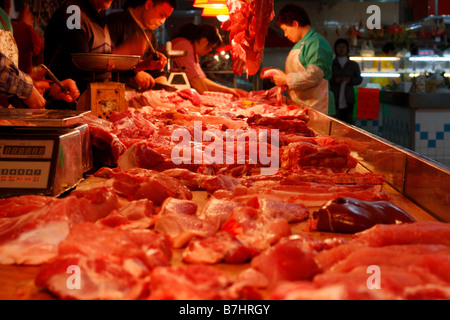 Chinese Butchers cutting meat in local market Stock Photo