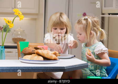 3 and 5 year old sisters having breakfast, B.C.