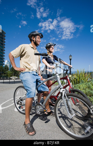 Young Couple Posed on Bicycles take in the view, Vancouver, British Columbia Stock Photo