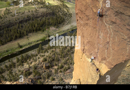 A group of men rock climbing on a free standing tower of rock., Smith Rock State Park, Terrebonne, Oregon, USA Stock Photo