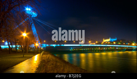 Bratislava by night. Futuristic restaurant UFO on the top of Novy Most bridge over The Donau. To the right: Bratislava Castle. Stock Photo