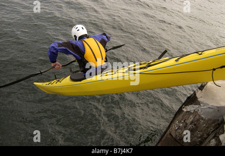 Man (30-35) dropping off a pier in an ocean kayak, Sidney, BC, Canada Stock Photo