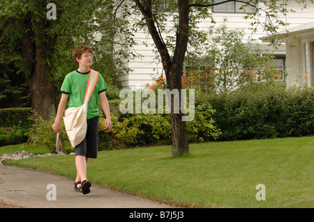 Newspaper boy walking down street, Regina, Saskatchewan Stock Photo