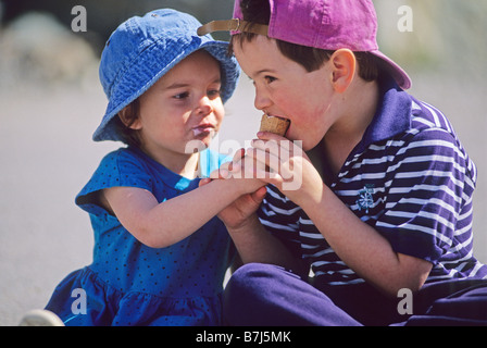 Boy,6, and girl, 3, share ice cream cone, Whistler, BC Canada Stock Photo