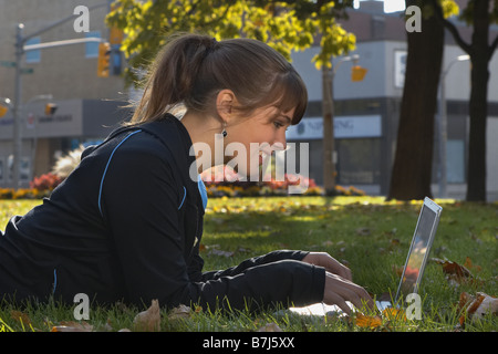 Young woman using laptop outdoors, Brantford, Ontario Stock Photo