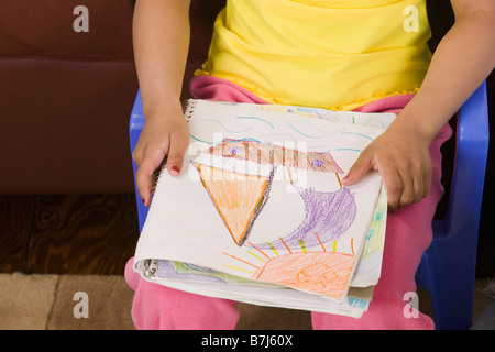 Mulatto girl 6 years old with her artwork. Stock Photo