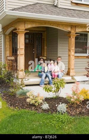 AA mom, Caucasian dad, Mulatto Children, Boy 1.5 years, girl 3 years, girl 6 years on the porch of their home. Abbotsford. BC Stock Photo