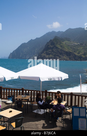 dh  PORTO DA CRUZ MADEIRA Young male and females outdoor cafe and north rugged coast outdoors holiday people drinking girls al fresco outside Stock Photo