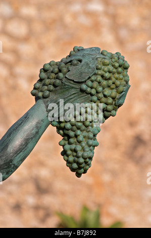 Statue of a girl holding a bunch of grapes and a basket by R Cuello