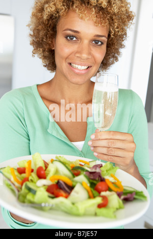 Mid Adult Woman Holding A Wine Glass And Fresh Salad Stock Photo