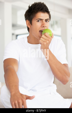 Young Man Eating A Green Apple Stock Photo