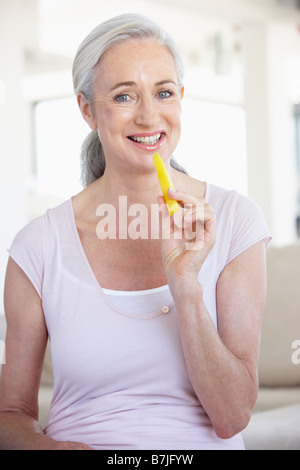 Senior Woman Eating Pineapple Stock Photo