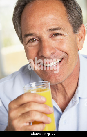 Middle Aged Man Drinking Fresh Orange Juice Stock Photo