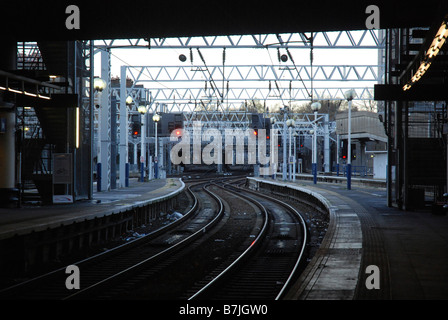 Euston station platform end empty track snaking away under the wires Stock Photo