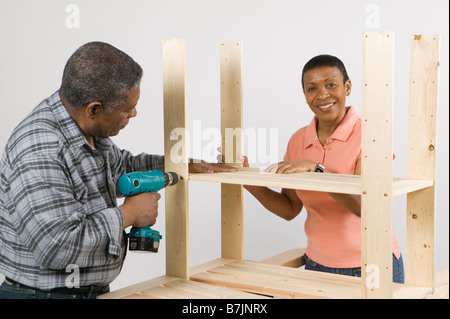 African American Couple Doing Home Improvement, Assembling a Shelving Unit, Canada, British Columbia Stock Photo
