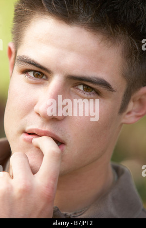 Portrait Of Teenage Boy Biting Nails Stock Photo