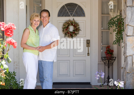 Couple Standing Outside Their House Stock Photo