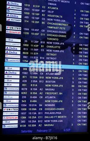 Airport Arrivals Board electronic screen monitor displays domestic flights of airlines all arriving on time. Stock Photo