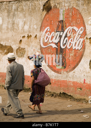 Villagers walking past Coca Cola logo Stock Photo