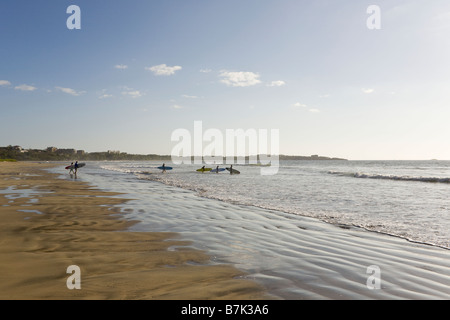 Surfers walking into the surf in Playa Grande, Costa Rica. Stock Photo