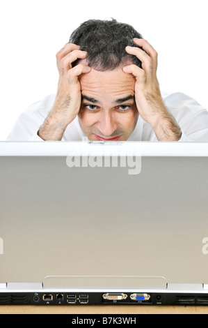 Stressed businessman sitting at his desk isolated on white background Stock Photo