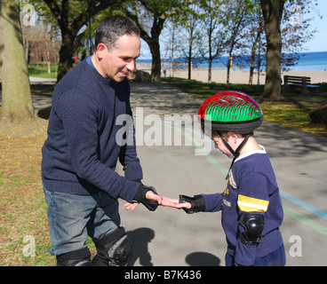 Father and son rollerblading together Stock Photo