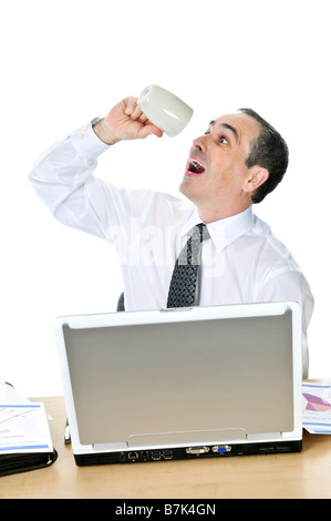 Overworked businessman with coffee mug at his desk isolated on white background Stock Photo