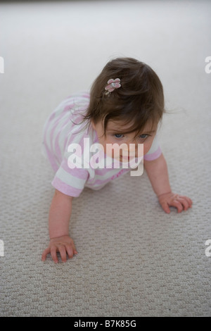 A seven month old baby girl crawling Stock Photo