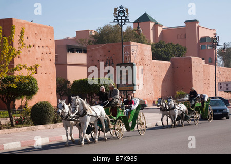 Two caleche horse drawn carriages giving tourist sightseeing tours outside the Medina walls. Marrakech Morocco North Africa Stock Photo
