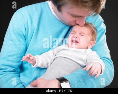 man comforting screaming baby Stock Photo