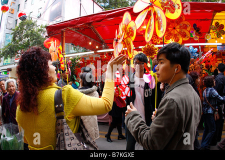 Chinese Students selling traditional lucky pinwheels at Flower market durring Chinese New Year Stock Photo