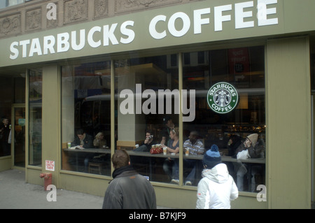 Starbucks customers enjoy their coffee in a Starbucks coffee shop in Times Square Stock Photo