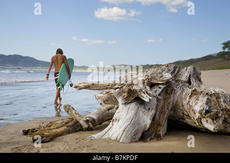 Surfer walking on the shore of Playa Grande in Costa Rica. Stock Photo