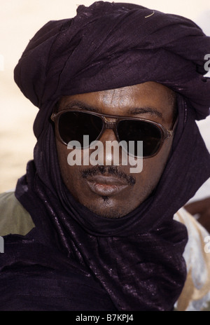 Akadaney, Niger, West Africa. Fulani Man wearing Tuareg Indigo Tagelmust, Sunglasses. Stock Photo