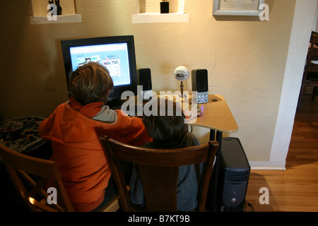 two boys watching an episode from cartoon network online computer, through internet Stock Photo