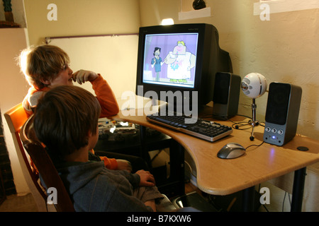 two boys watching an episode from cartoon network online computer, through internet Stock Photo