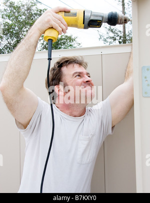 Handyman using a power drill on a project Stock Photo