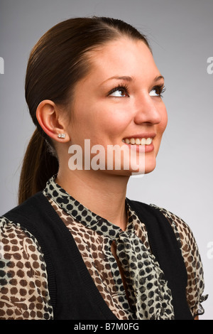 Attractive young woman smiling and looking away Stock Photo