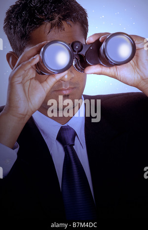 Businessman with binoculars Stock Photo