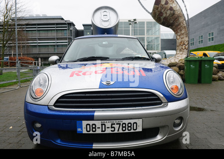 Front of a Red Bull liveried BMW Mini with large replica drinks can mounted on rear Stock Photo