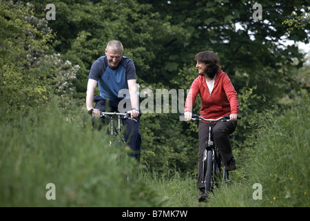 Couple cycling on the disused railway line near Market Weighton The Wolds East Yorkshire UK Stock Photo