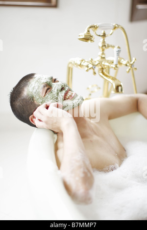 Man on Cell Phone Soaking in a Bubble Bath Stock Photo